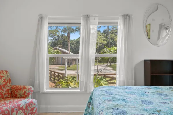 a bedroom with a bed a window and a painting on the wall