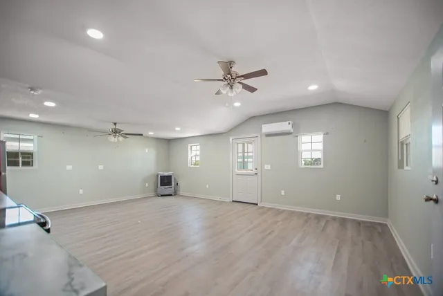 an empty room with window and ceiling fan