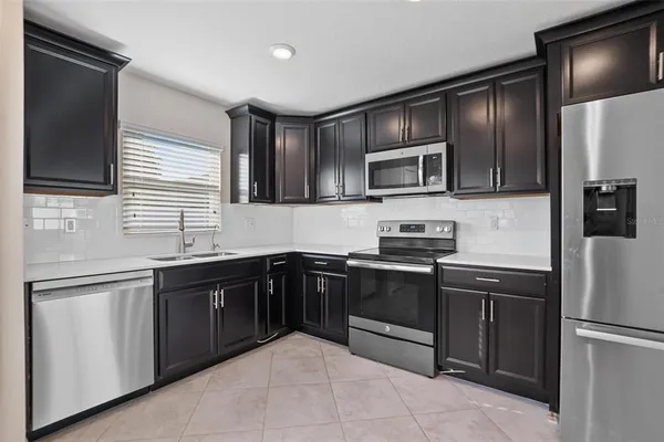 a kitchen with stainless steel appliances granite countertop a refrigerator and a stove top oven