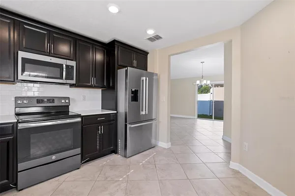 a large kitchen with a refrigerator and a sink