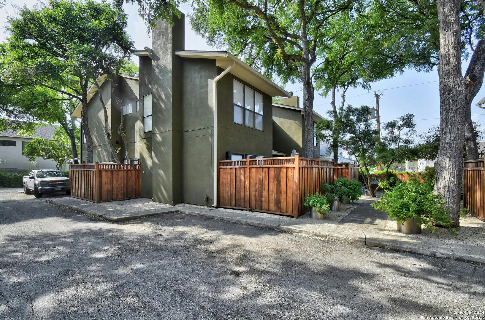 143 Terrell Road, Unit 1/2 San Antonio, TX 78209 - Photo 25 of 31 a view of a house with a small yard and large trees
