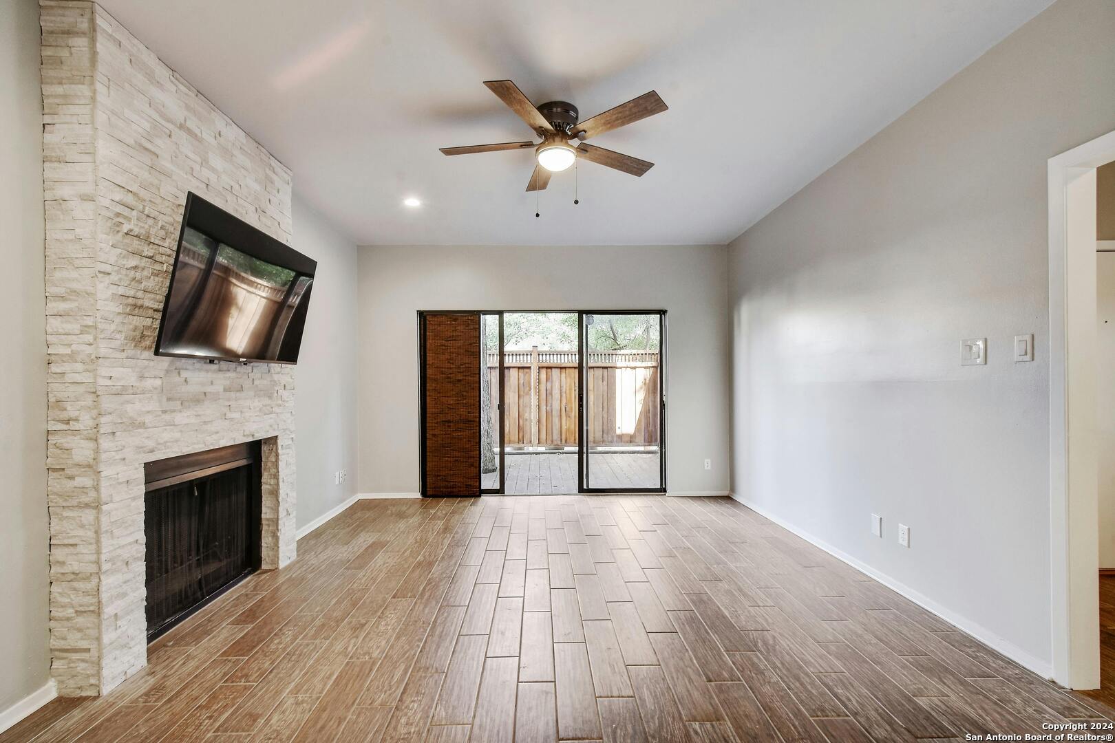 143 Terrell Road, Unit 1/2 San Antonio, TX 78209 - Photo 3 of 31 a view of empty room with wooden floor and fireplace