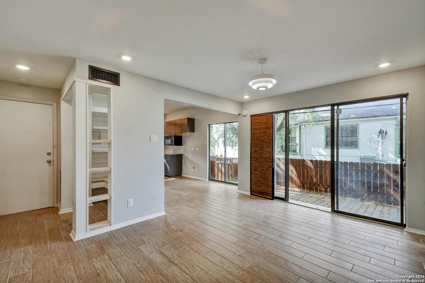 143 Terrell Road, Unit 1/2 San Antonio, TX 78209 - Photo 5 of 31 a view of an empty room with wooden floor and a window