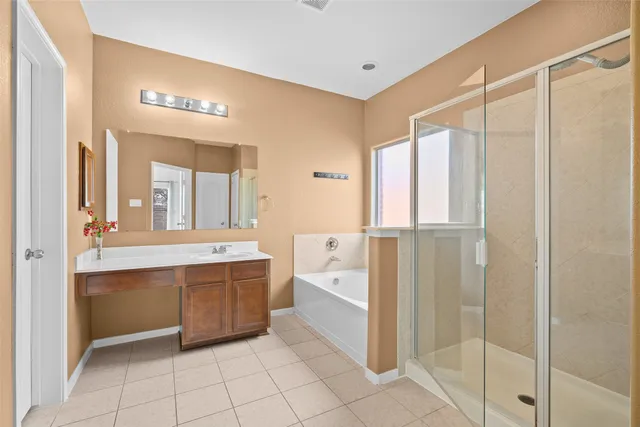 a bathroom with a tub sink shower and mirror