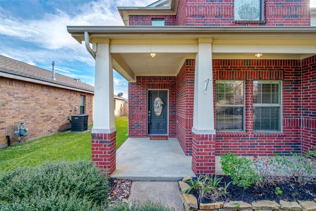 a view of a house with potted plants and a yard