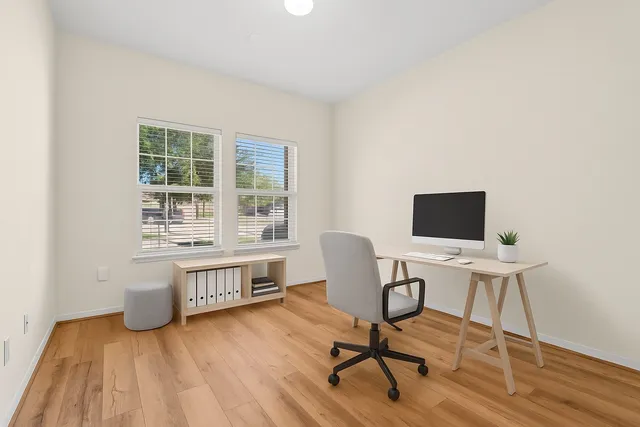 a view of a workspace with furniture and a window