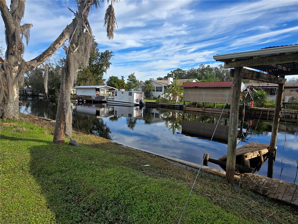 55716 Keith Street Astor, FL 32102 - Photo 2 of 12 a view of a patio with table and chairs potted plants with wooden floor and fence