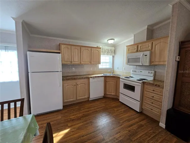 a kitchen with granite countertop white cabinets and white appliances