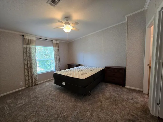 a spacious bedroom with a bed and a window