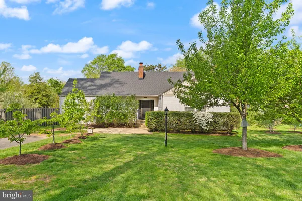 a view of a big house with a big yard and a large tree