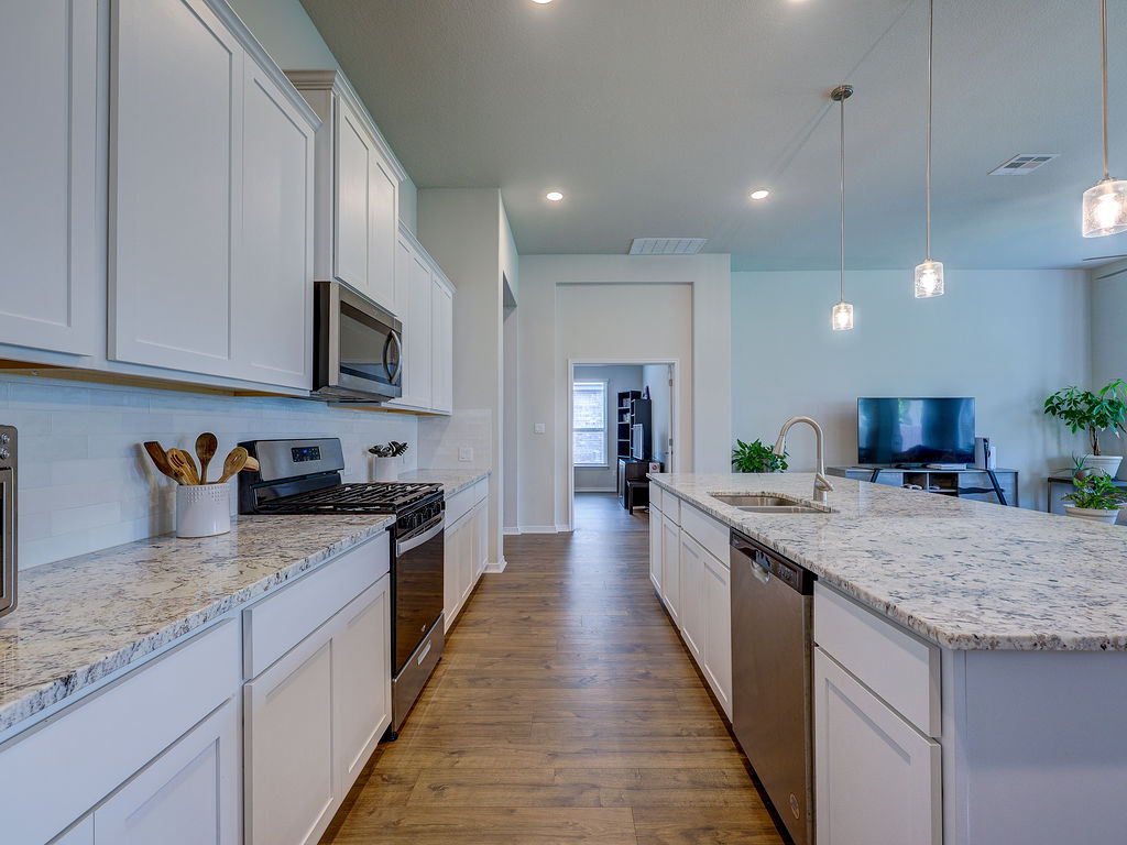 229 Heartleaf Road San Marcos, TX 78666 - Photo 13 of 40 A streamlined kitchen design with gleaming countertops offers functional elegance.