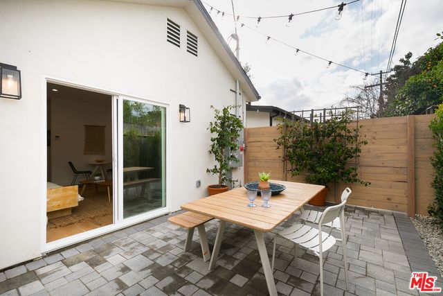a view of a patio with table and chairs and potted plants