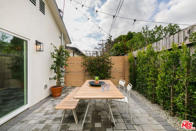a view of a patio with a table and chairs and potted plants