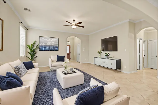 a living room with furniture flat screen tv and couches