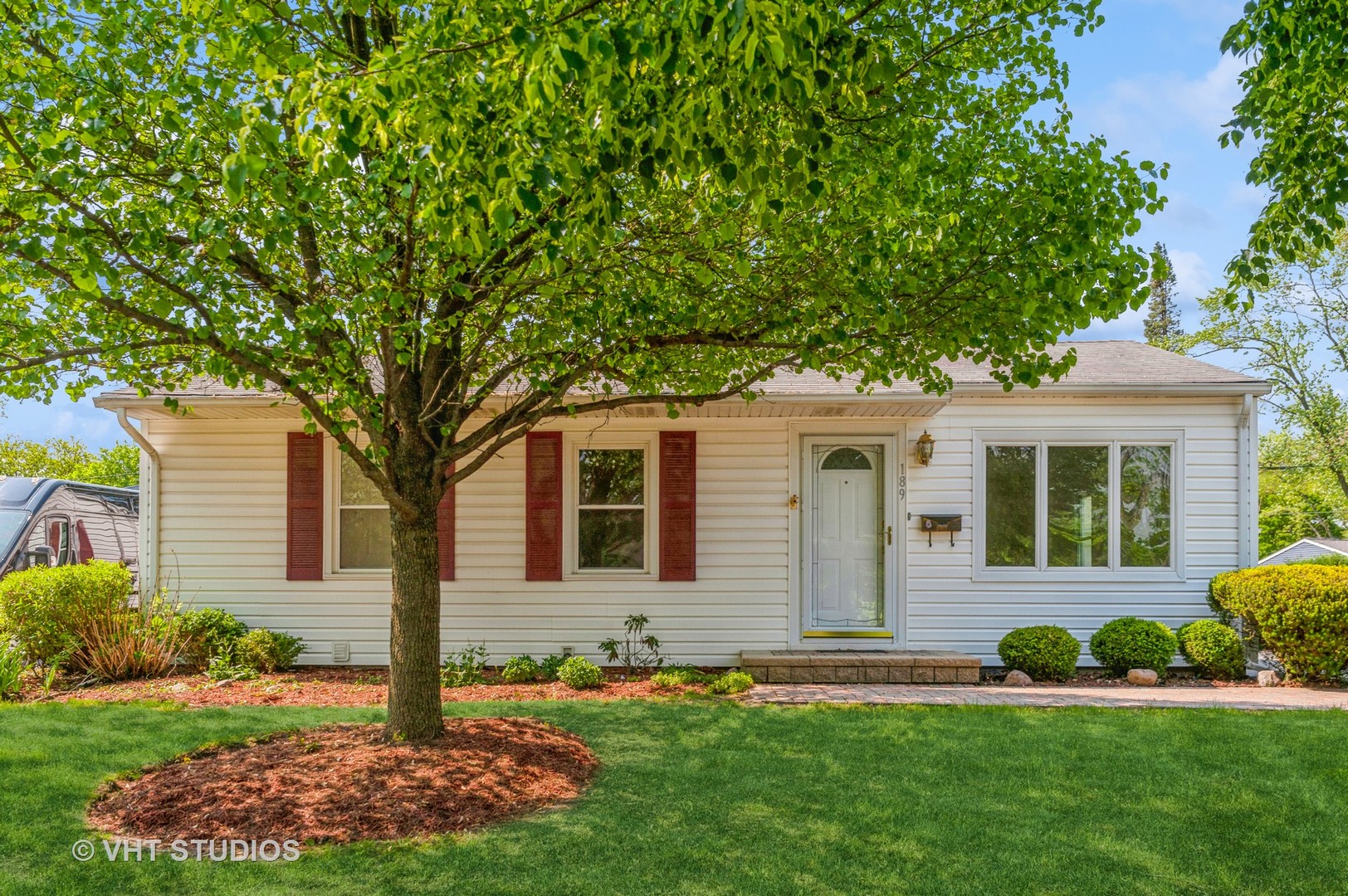 a front view of a house with a yard and trees