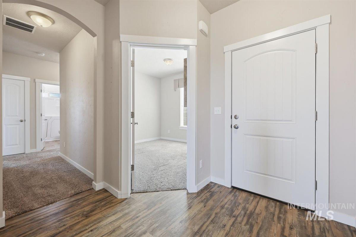 13496 Hockberger Ranch Road Caldwell, ID 83607 - Photo 7 of 40 Entryway featuring wood-finish flooring, a paneled door with white trim, and light gray wall paint