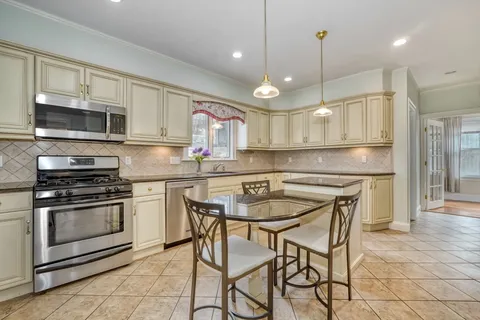 a kitchen with stainless steel appliances a stove a sink a microwave a refrigerator and cabinets