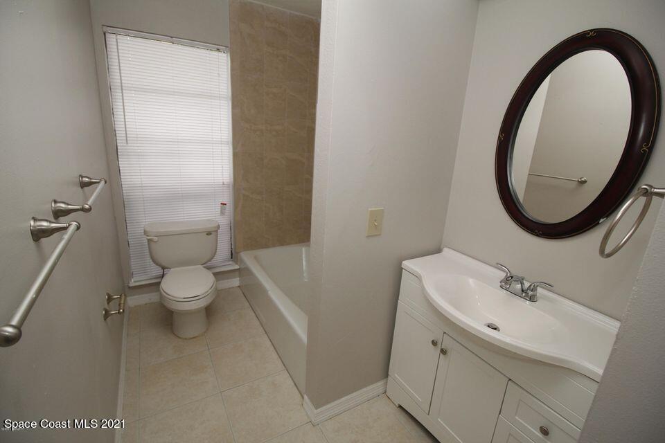 1495 Norbert Road Northeast Palm Bay, FL 32907 - Photo 8 of 10 a bathroom with a toilet sink and a mirror