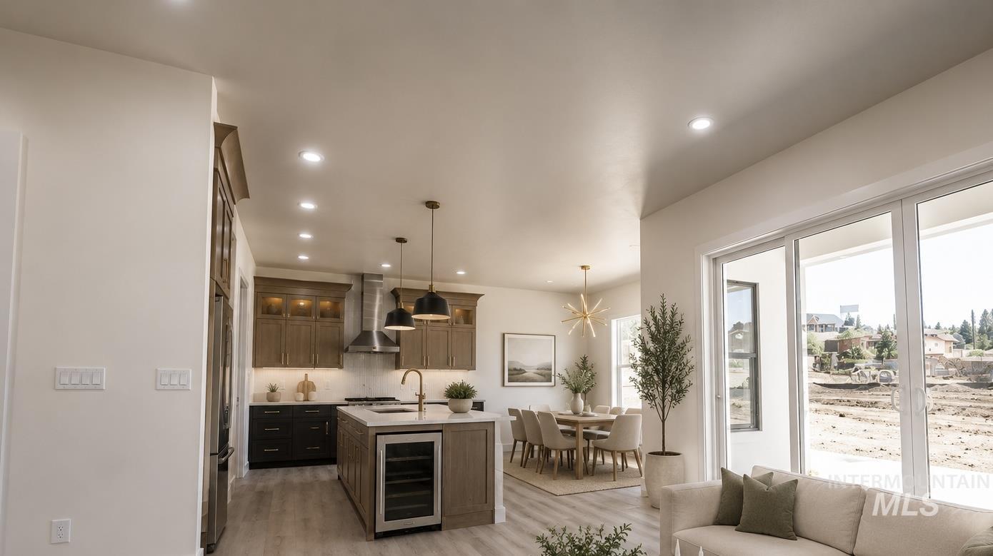 23904 Southview Lane Middleton, ID 83644 - Photo 7 of 29 Open-concept living space featuring a gourmet kitchen with stainless steel appliances, a center island with beverage cooler, and pendant lighting
