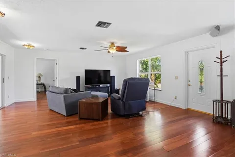 a living room with furniture a flat screen tv and a window