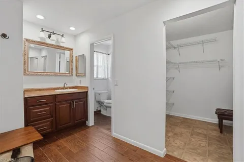 a spacious bathroom with a granite countertop sink a mirror and a toilet
