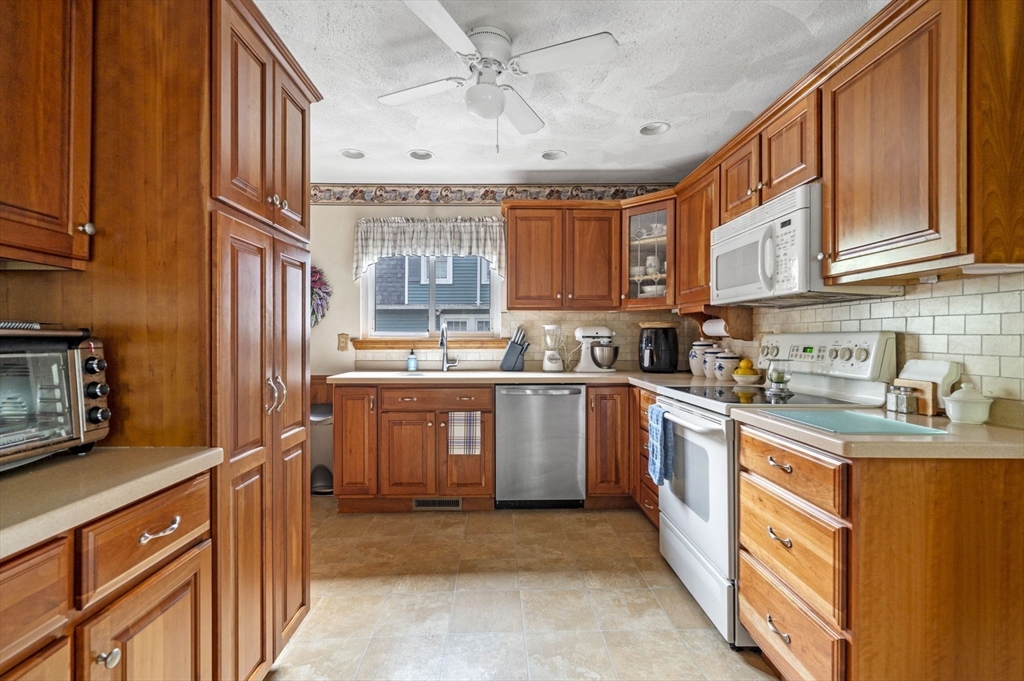 3 Trask Street Danvers, MA 01923 - Photo 14 of 29 a kitchen with stainless steel appliances granite countertop a sink a stove cabinets counter space and a window