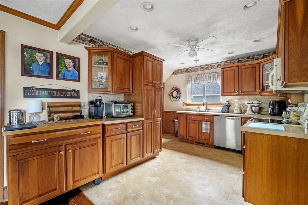 3 Trask Street Danvers, MA 01923 - Photo 3 of 29 a kitchen with stainless steel appliances granite countertop a refrigerator a sink dishwasher a stove with wooden cabinets