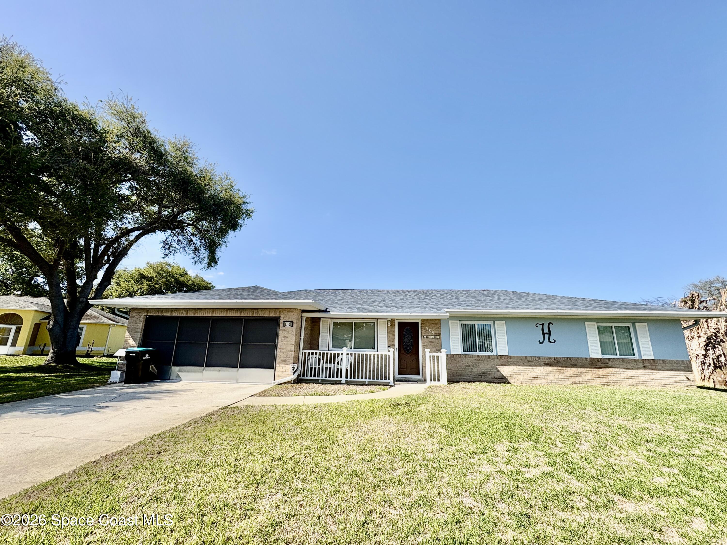 585 Crystal Mist Road Northwest Palm Bay, FL 32907 - Photo 1 of 21 a front view of a house with a yard and garage