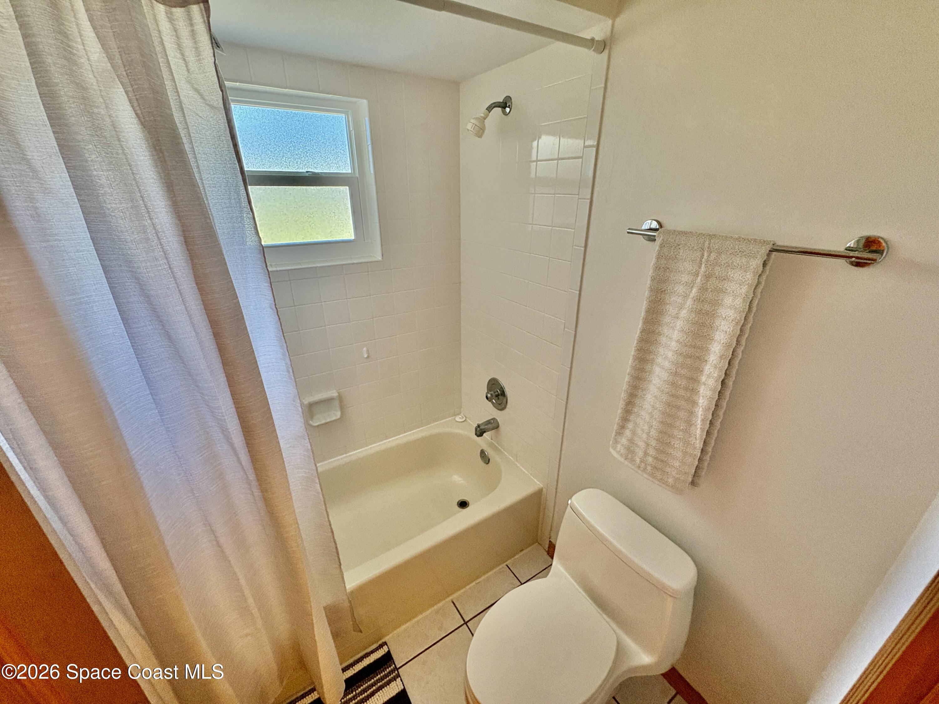 585 Crystal Mist Road Northwest Palm Bay, FL 32907 - Photo 14 of 21 a bathroom with a toilet and a tub