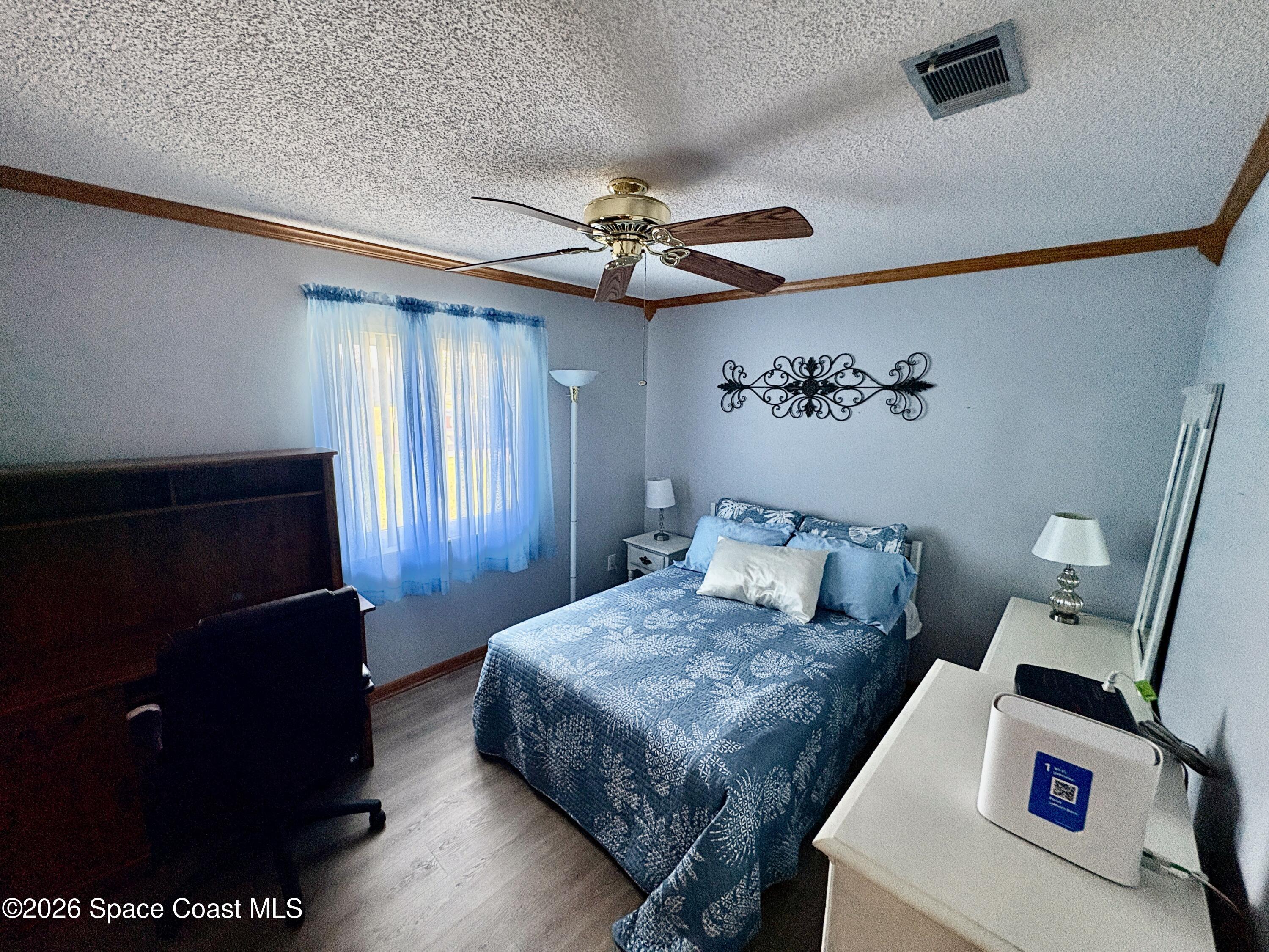 585 Crystal Mist Road Northwest Palm Bay, FL 32907 - Photo 15 of 21 a bedroom with a bed and a chandelier