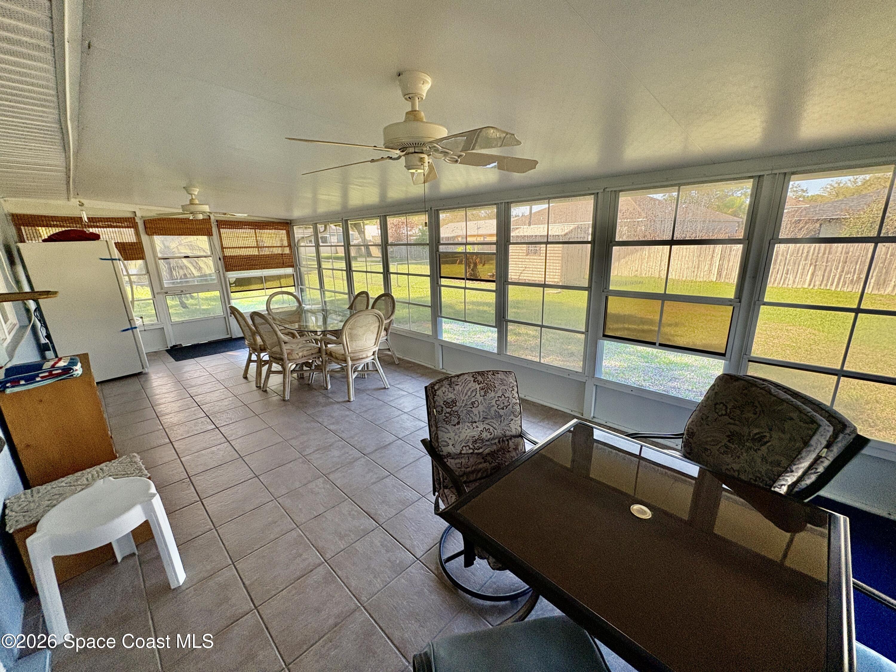 585 Crystal Mist Road Northwest Palm Bay, FL 32907 - Photo 16 of 21 a living room with furniture and floor to ceiling windows
