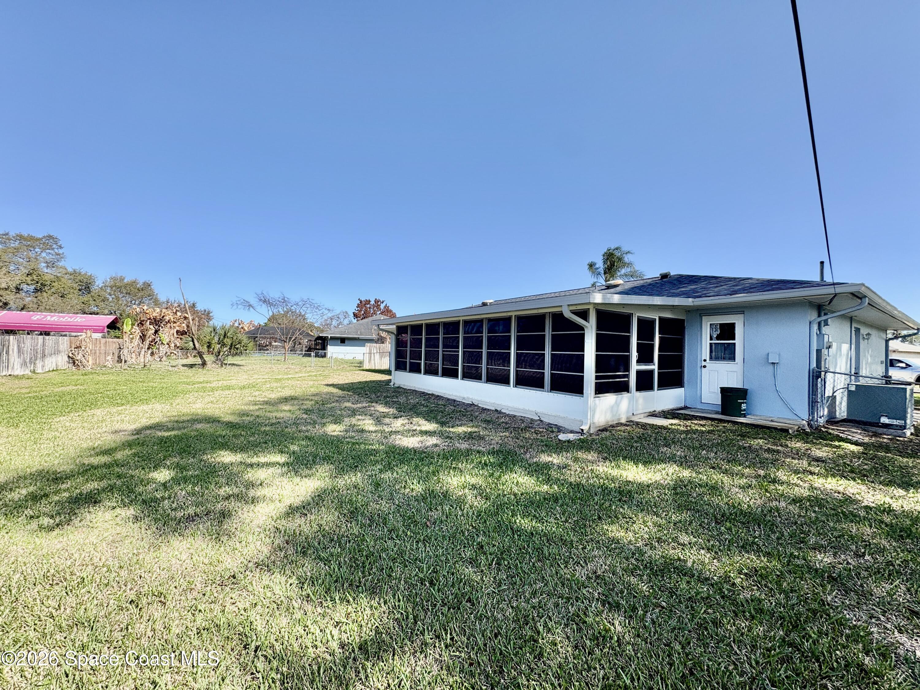 585 Crystal Mist Road Northwest Palm Bay, FL 32907 - Photo 20 of 21 a view of a house with a yard