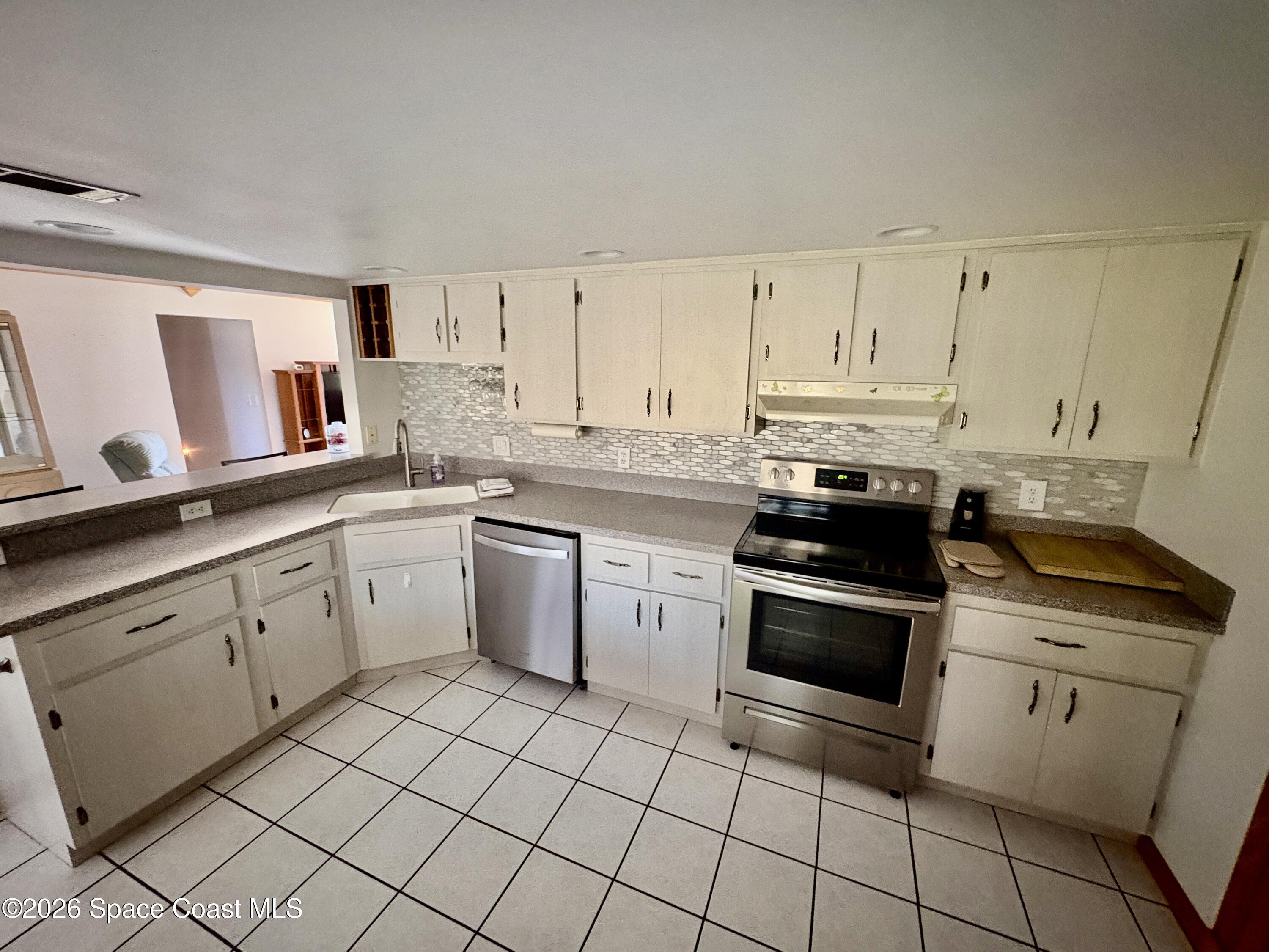 585 Crystal Mist Road Northwest Palm Bay, FL 32907 - Photo 2 of 21 a kitchen with cabinets appliances and a sink