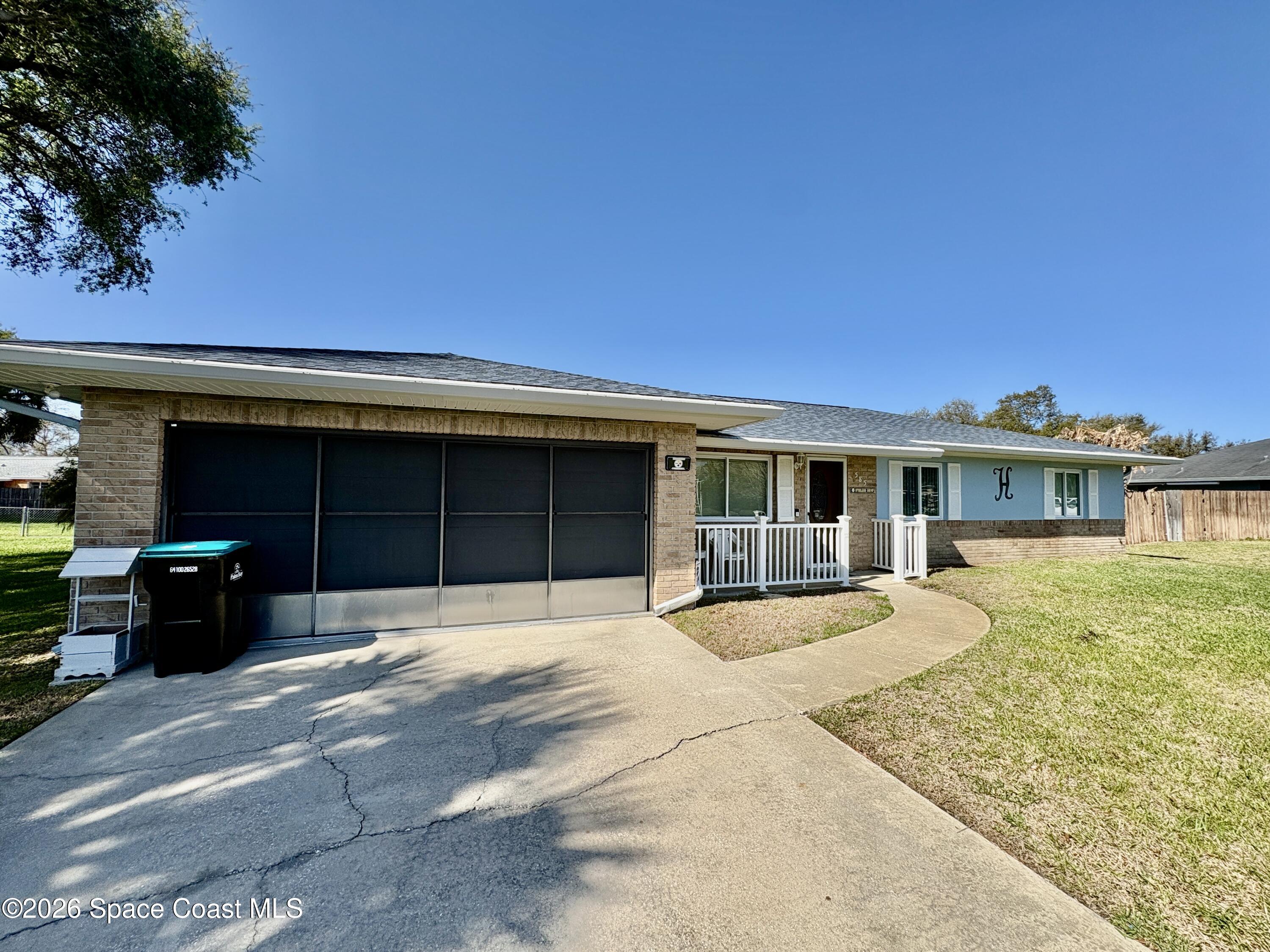 585 Crystal Mist Road Northwest Palm Bay, FL 32907 - Photo 21 of 21 a front view of a house with a yard and garage