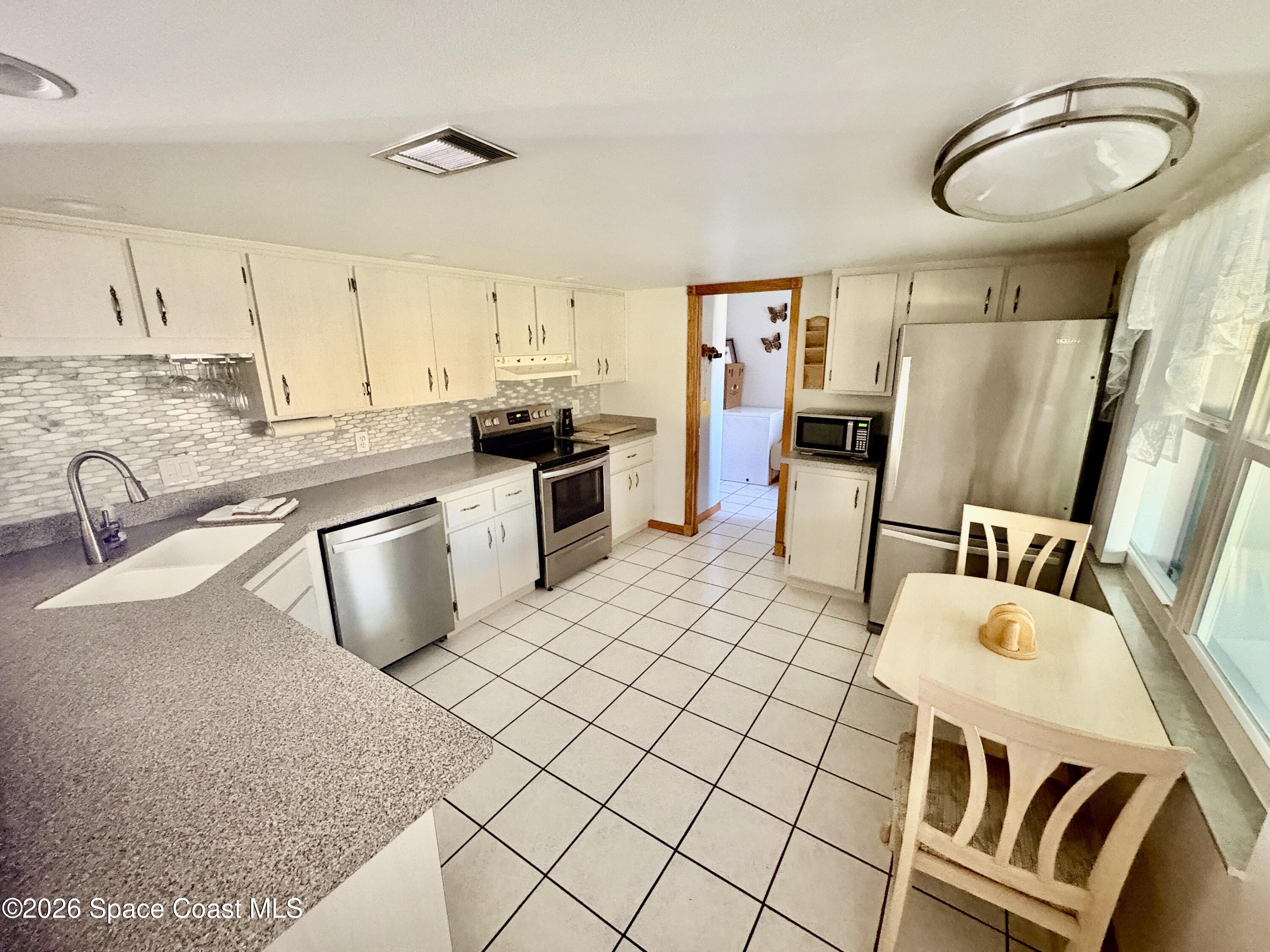 585 Crystal Mist Road Northwest Palm Bay, FL 32907 - Photo 3 of 21 a kitchen with a sink appliances and cabinets
