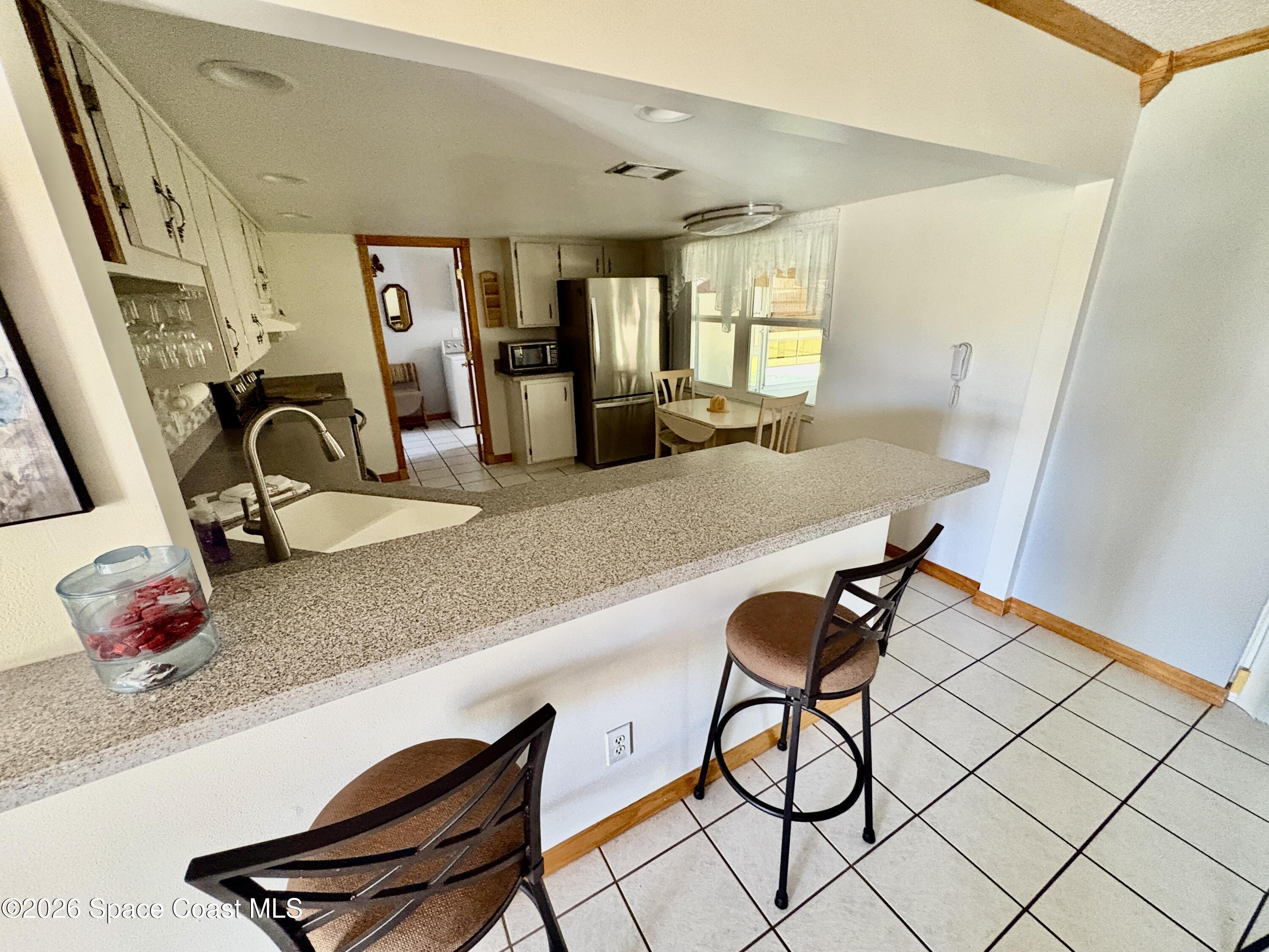 585 Crystal Mist Road Northwest Palm Bay, FL 32907 - Photo 4 of 21 a view of a kitchen with dining area and windows