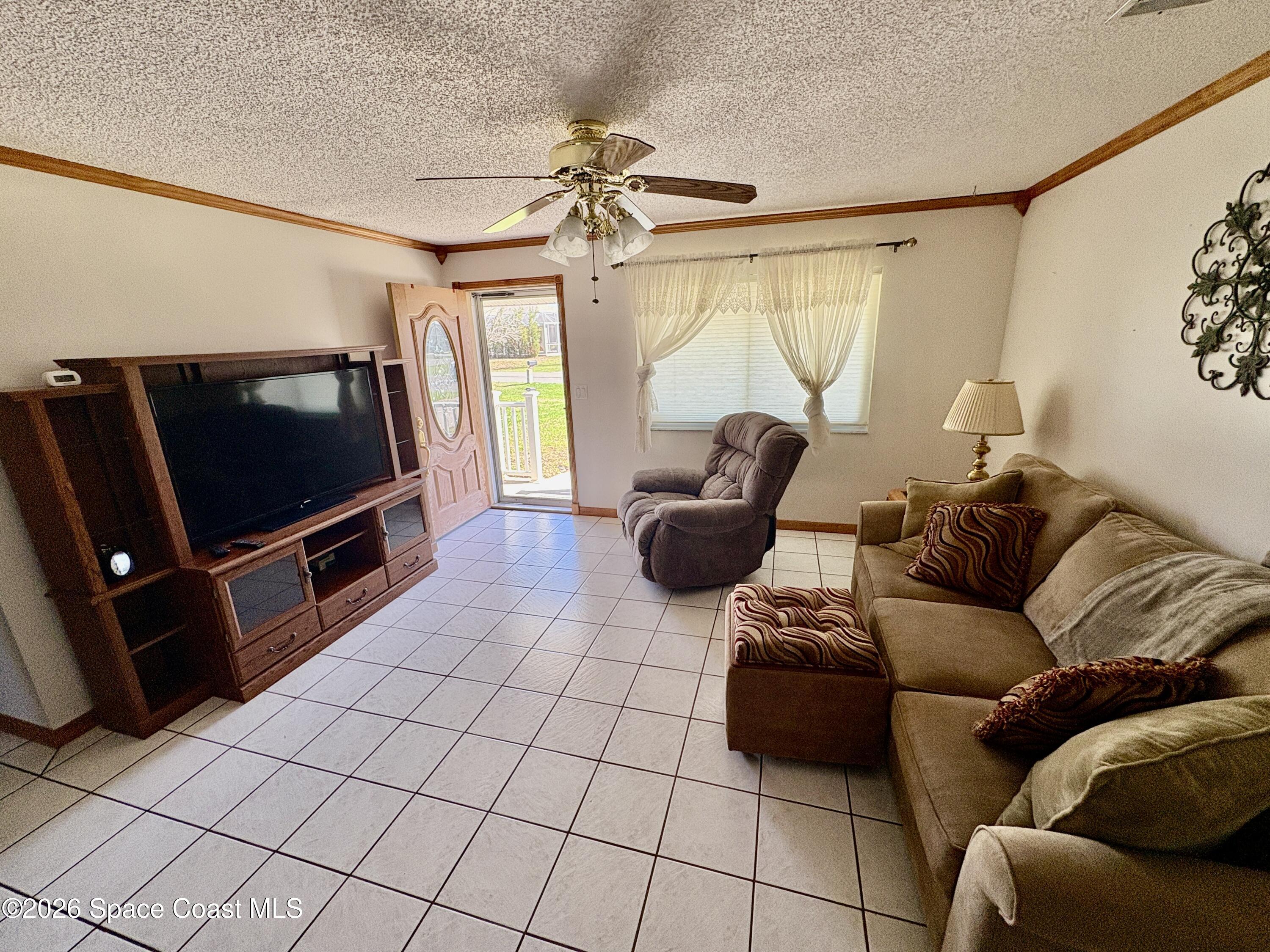 585 Crystal Mist Road Northwest Palm Bay, FL 32907 - Photo 7 of 21 a living room with furniture and a flat screen tv