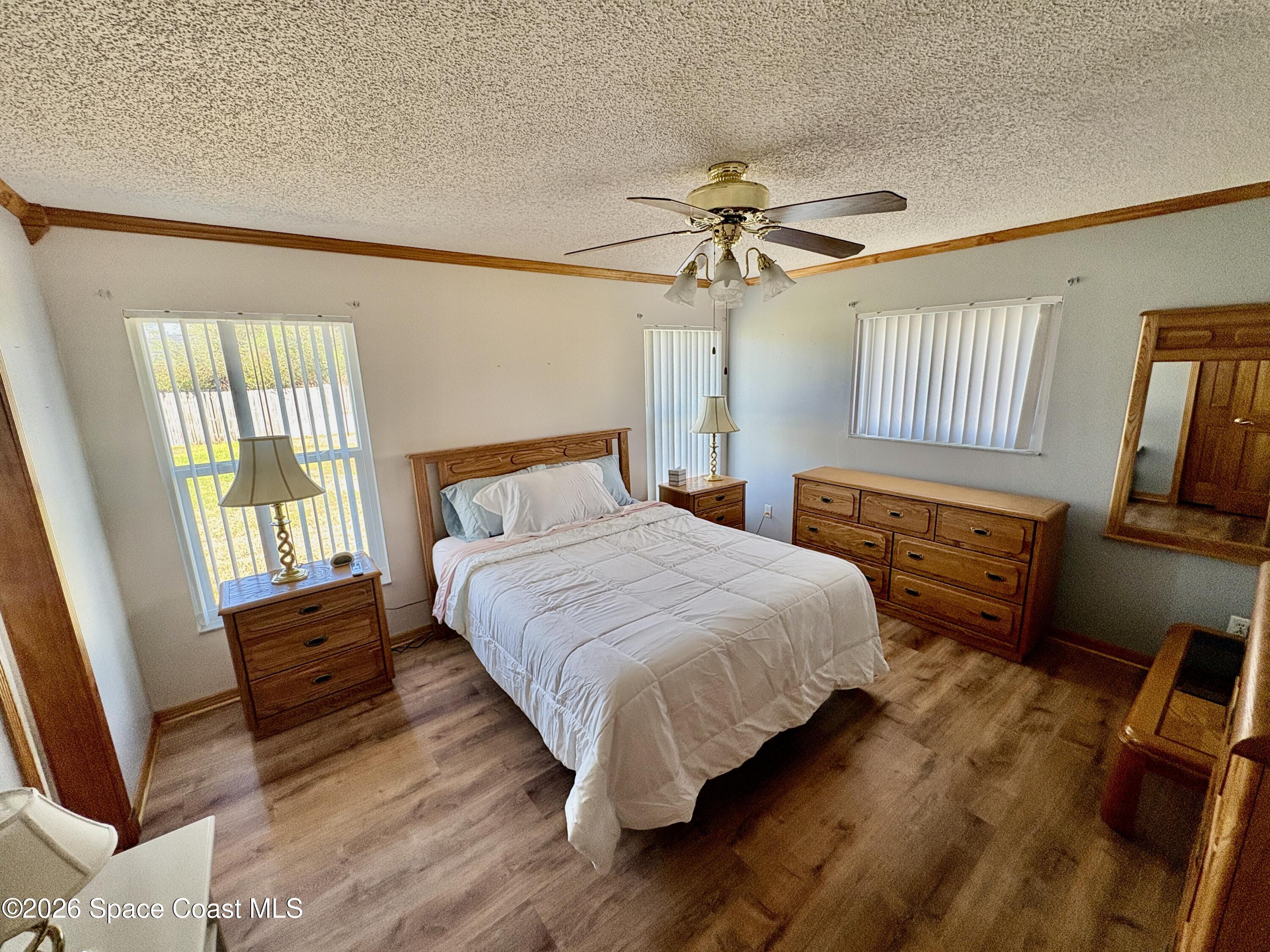 585 Crystal Mist Road Northwest Palm Bay, FL 32907 - Photo 8 of 21 a bedroom with a bed and wooden floor