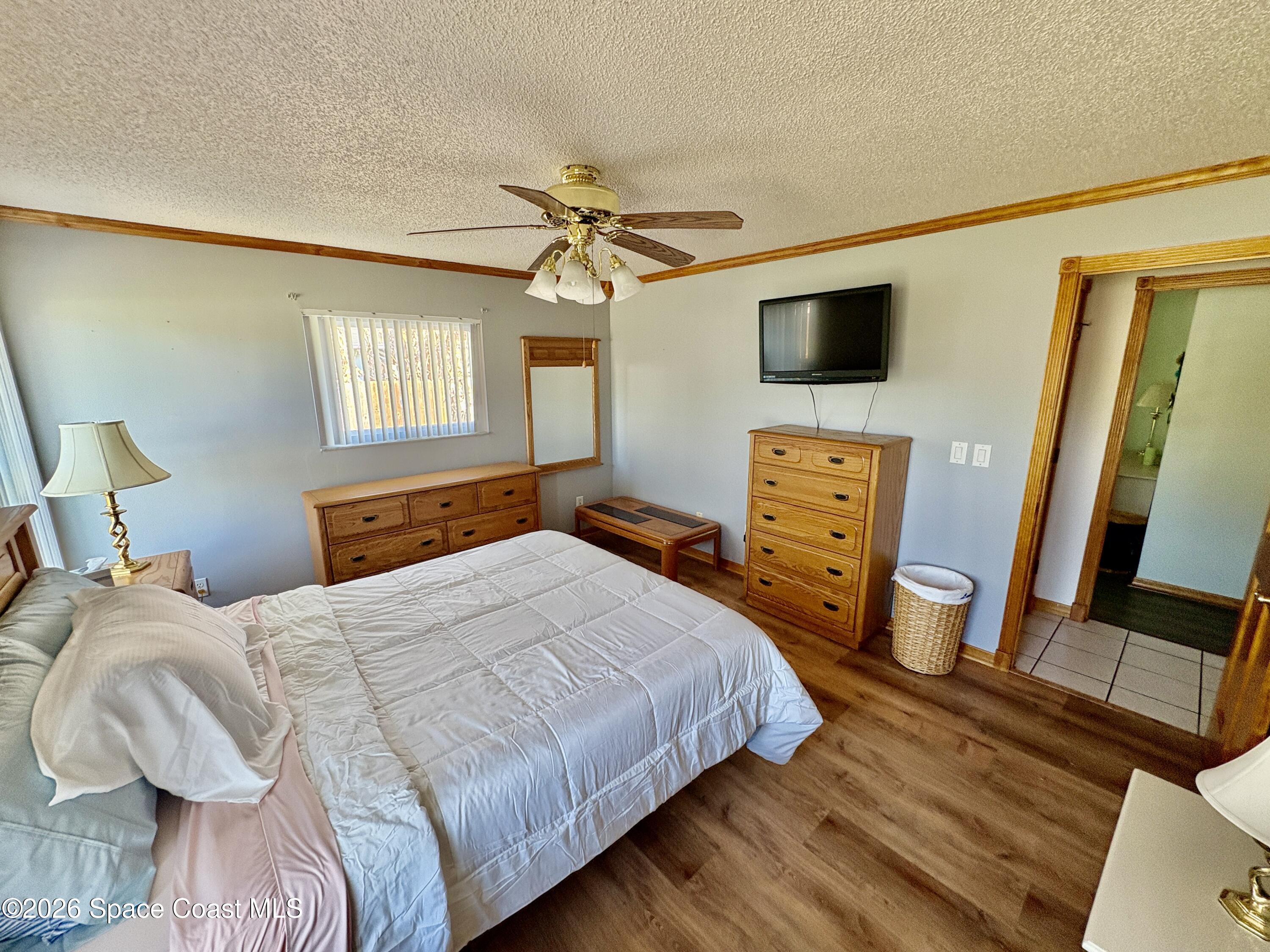 585 Crystal Mist Road Northwest Palm Bay, FL 32907 - Photo 9 of 21 a bedroom with a bed and a flat screen tv