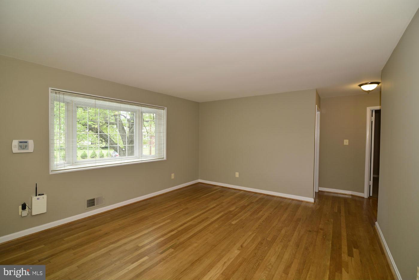 7115 Kerr Drive Springfield, VA 22150 - Photo 6 of 25 a view of an empty room with wooden floor and a window