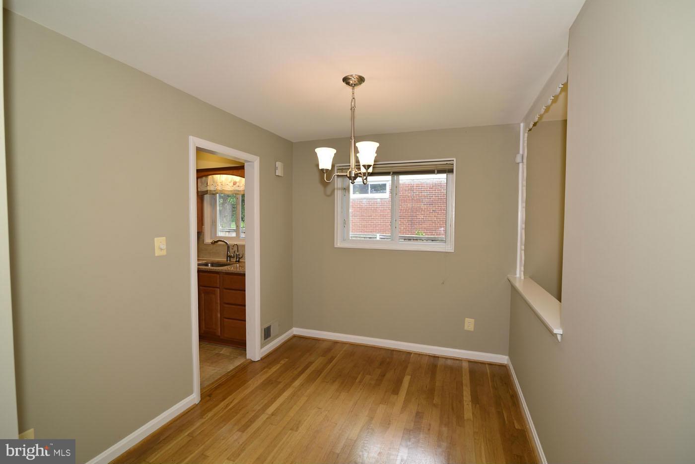 7115 Kerr Drive Springfield, VA 22150 - Photo 7 of 25 a view of an empty room with wooden floor and a window
