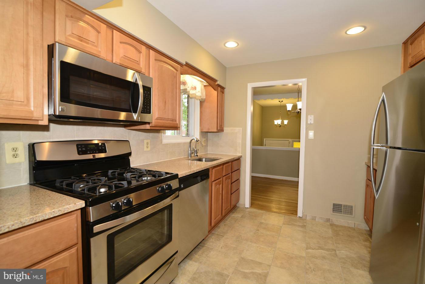 7115 Kerr Drive Springfield, VA 22150 - Photo 9 of 25 a kitchen with stainless steel appliances granite countertop a stove a refrigerator and a microwave