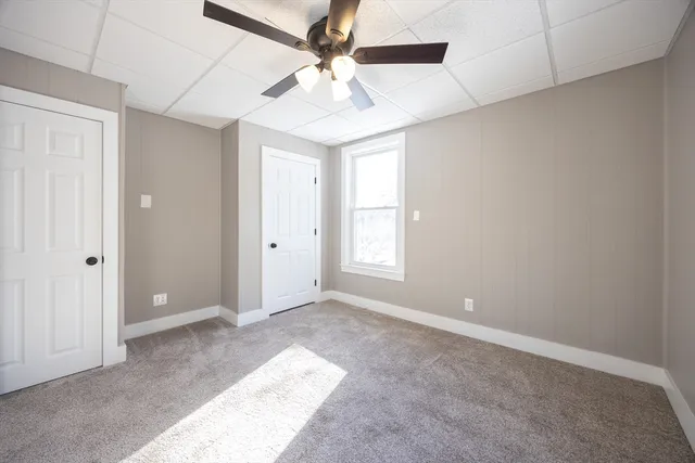 an empty room with fan and windows