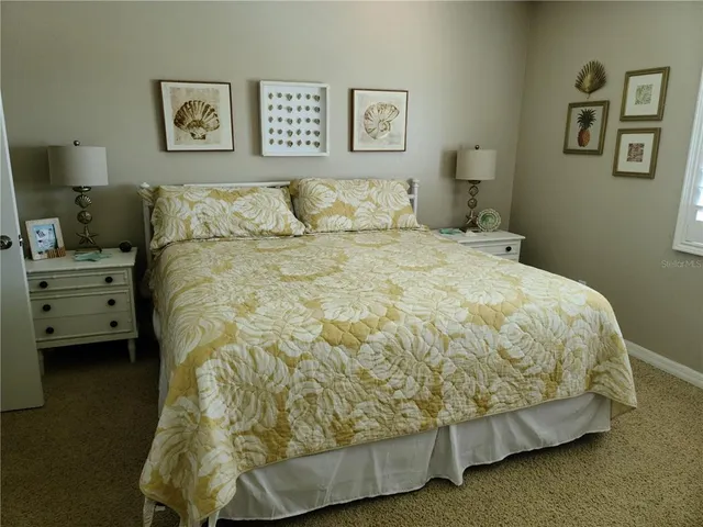 a bedroom with a bed and painting on the wall