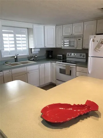 a kitchen with stainless steel appliances a refrigerator sink and cabinets