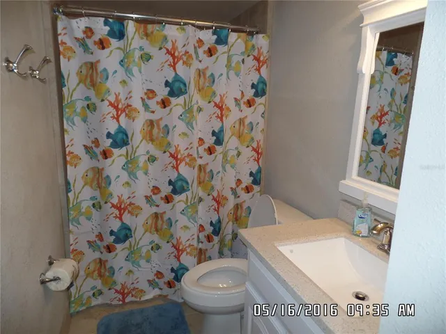 a white toilet sitting next to a shower curtain