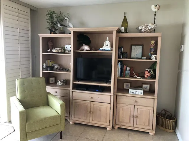 a living room with furniture cabinets and window
