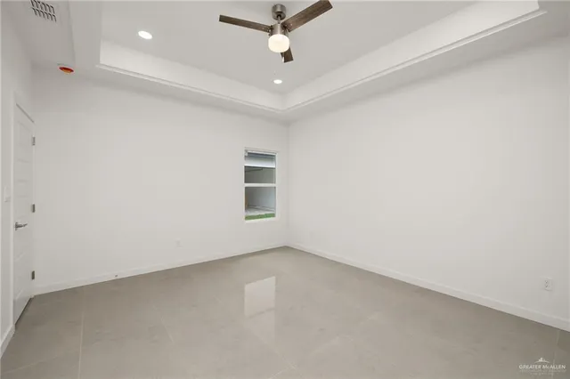 an empty room with a ceiling fan and window