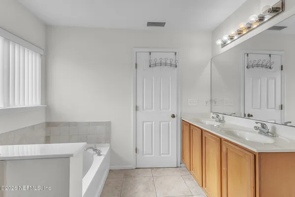 a bathroom with a tub sink and mirror