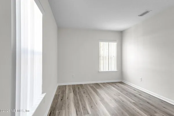 a view of a room with wooden floor and window